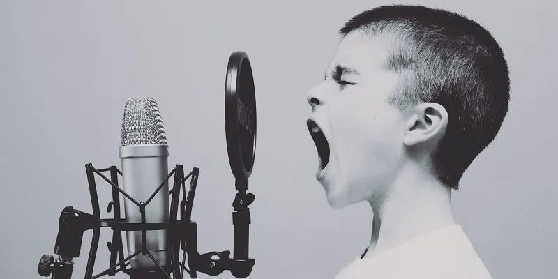 Listen up! child shouting into microphone to make people listen